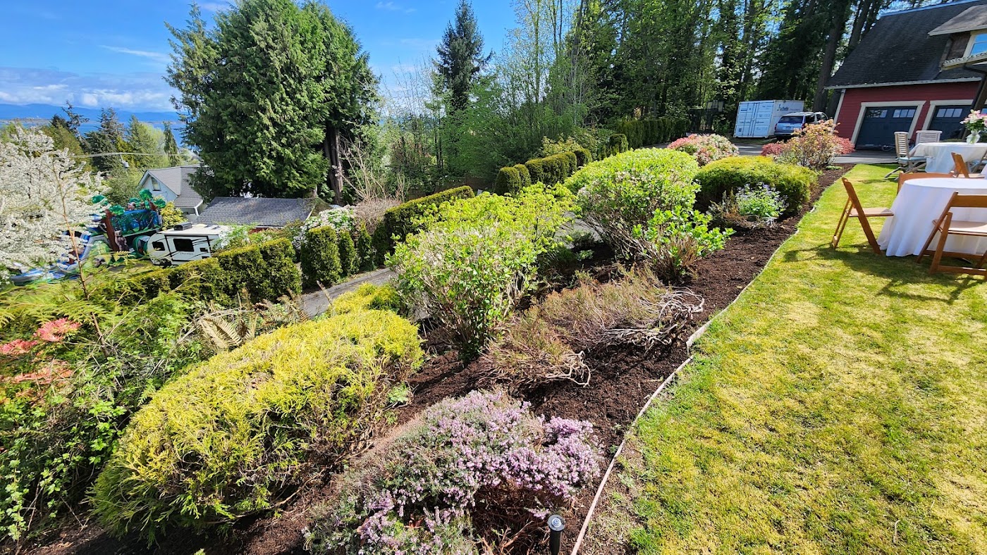 Mulched garden beds and established shrubs beside a neatly edged lawn