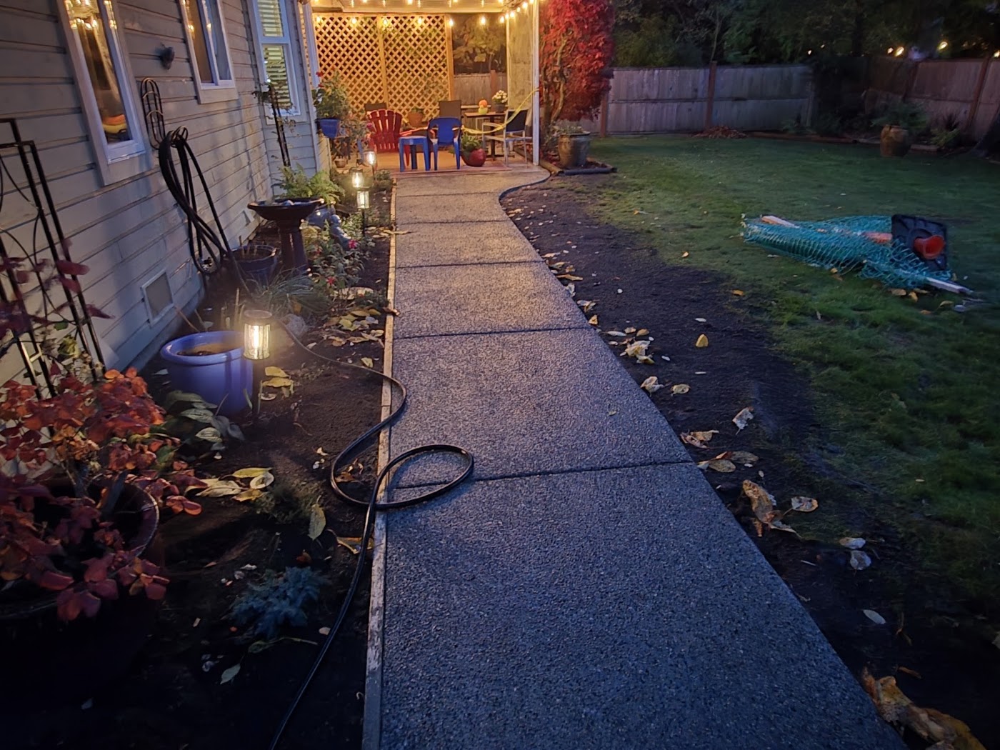 Finished concrete walkway leading to a covered outdoor sitting area